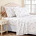 Taupe bedding set with a delicate dandelion print, styled on a bed with a tufted headboard, matching pillows, and a coordinating nightstand in a bright bedroom.
#color_dreamseed-taupe