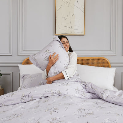 Lady hugging pillow with Myosotis Duvet Cover Sheet Set in Grey#color_myosotis-grey