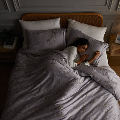 Lady sleeping on Myosotis Duvet Cover Sheet Set in Grey#color_myosotis-grey
