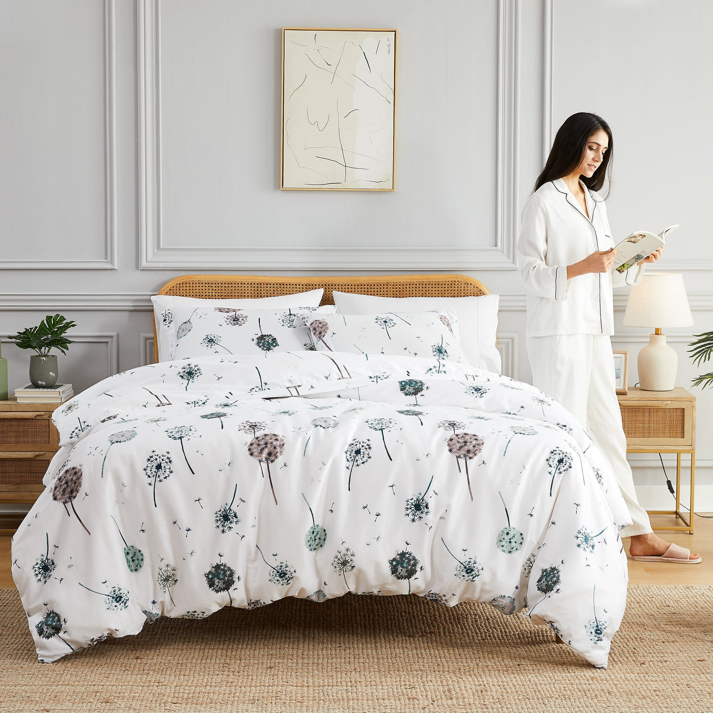 Lady reading a book next to Dandelion Dreams Duvet Cover in White#color_dandelion-white