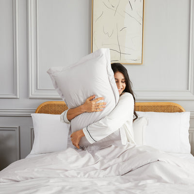 Lady hugging pillow with Percale Duvet Cover in Grey#color_percale-lunar-grey