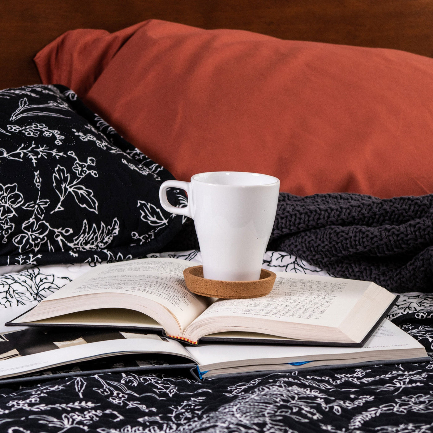 Books and coffee on top of Winter Brush Reversible Quilt Set in Black#color_winter-brush-black