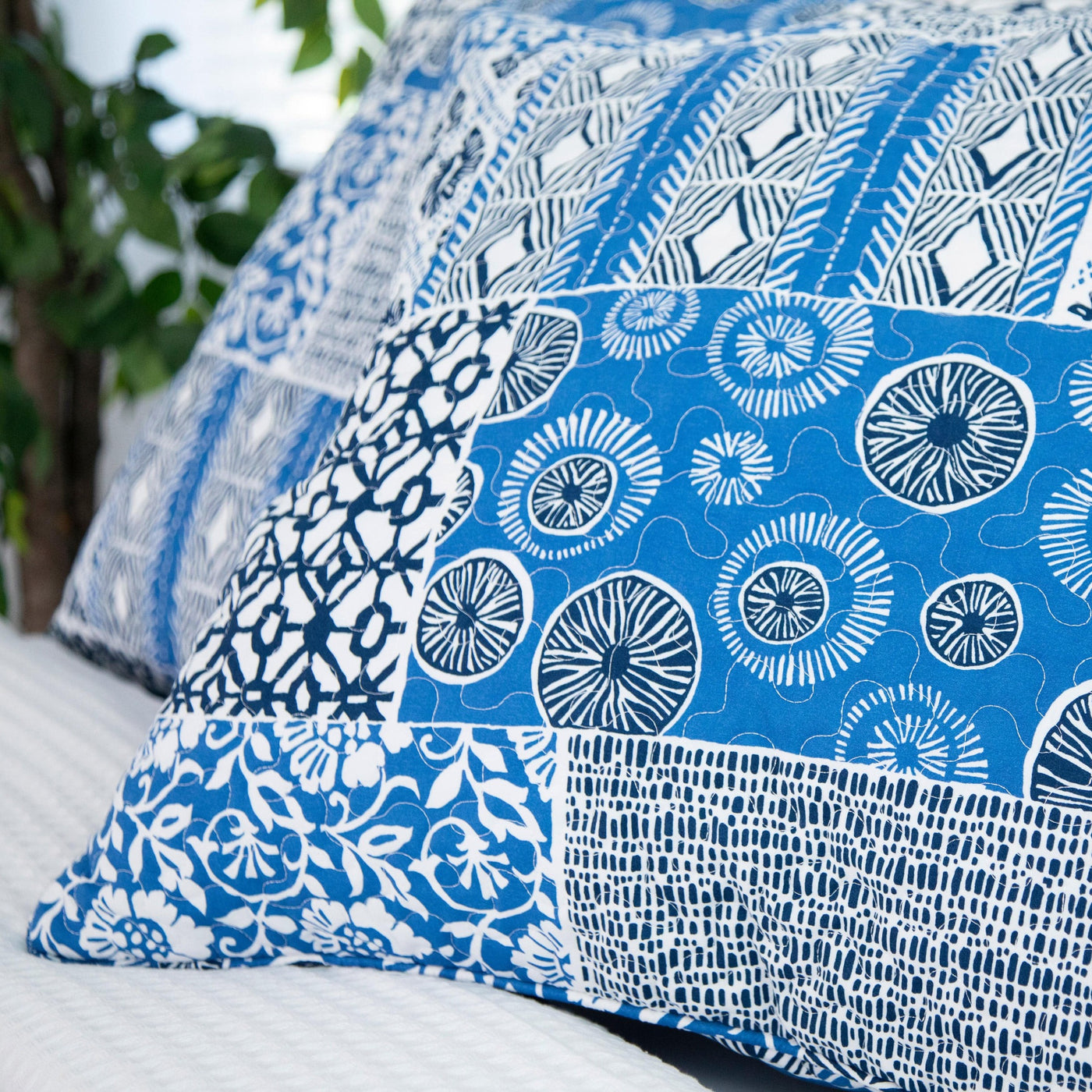 Details and Print Pattern of Global Patch Quilted Sham Covers in Blue#color_global-patch-blue