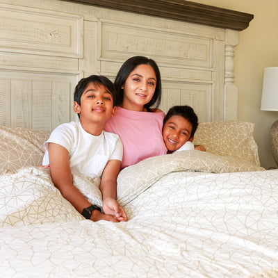 Family having fun on Geometric Maze Reversible Comforter Set in Taupe#color_geometric-maze-taupe