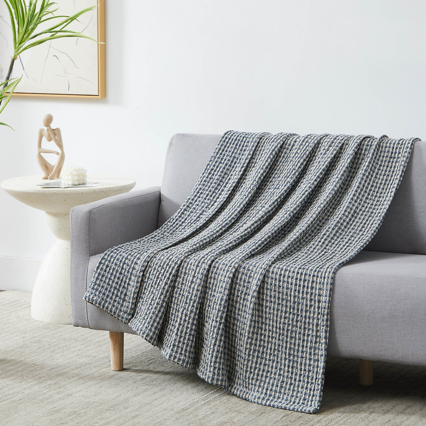 Tama Cotton Blanket and Throw in steel blue on sofa#color_tama-steel-blue