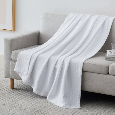 Milton Cotton Blankets and Throws in White on Sofa#color_milton-white