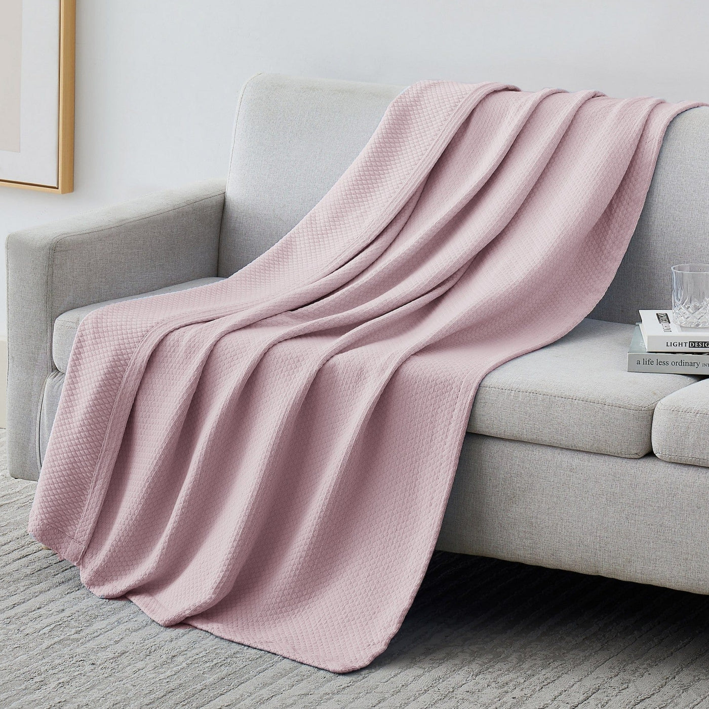 Milton Cotton Blankets and Throws in Pink on Sofa#color_milton-pink