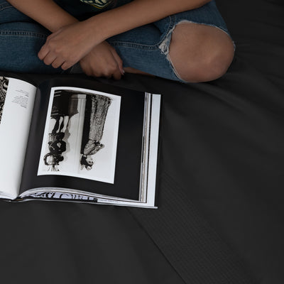 Lady Reading A Magazine on Vilano Extra Deep Pocket Pleated Sheet Set in Black#color_vilano-black